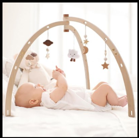 Arche d'éveil bébé en bois clair courbé avec suspensions sensorielles douces