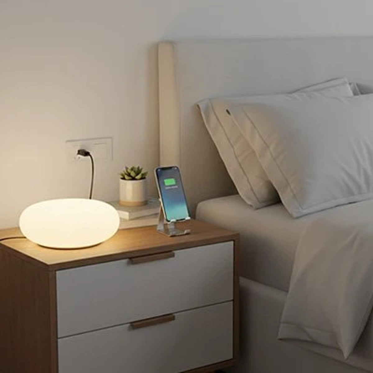 Lampe de chevet tactile posée sur une table de nuit blanche à côté du lit