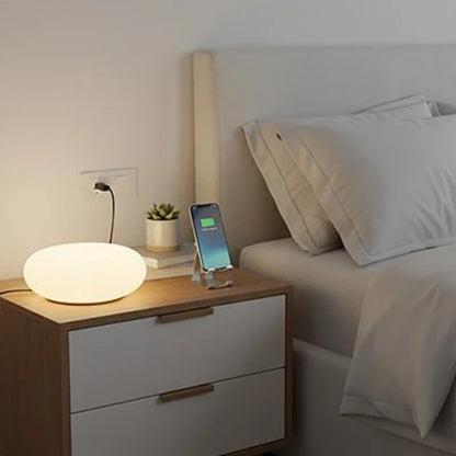 Lampe de chevet tactile posée sur une table de nuit blanche à côté du lit