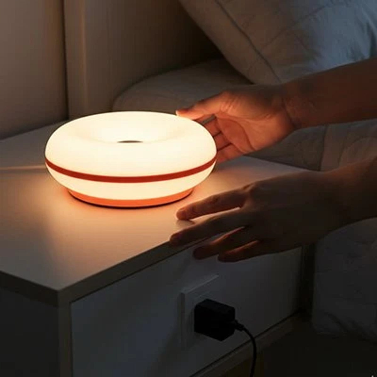 Main allumant la lampe de chevet tactile d'une simple pression